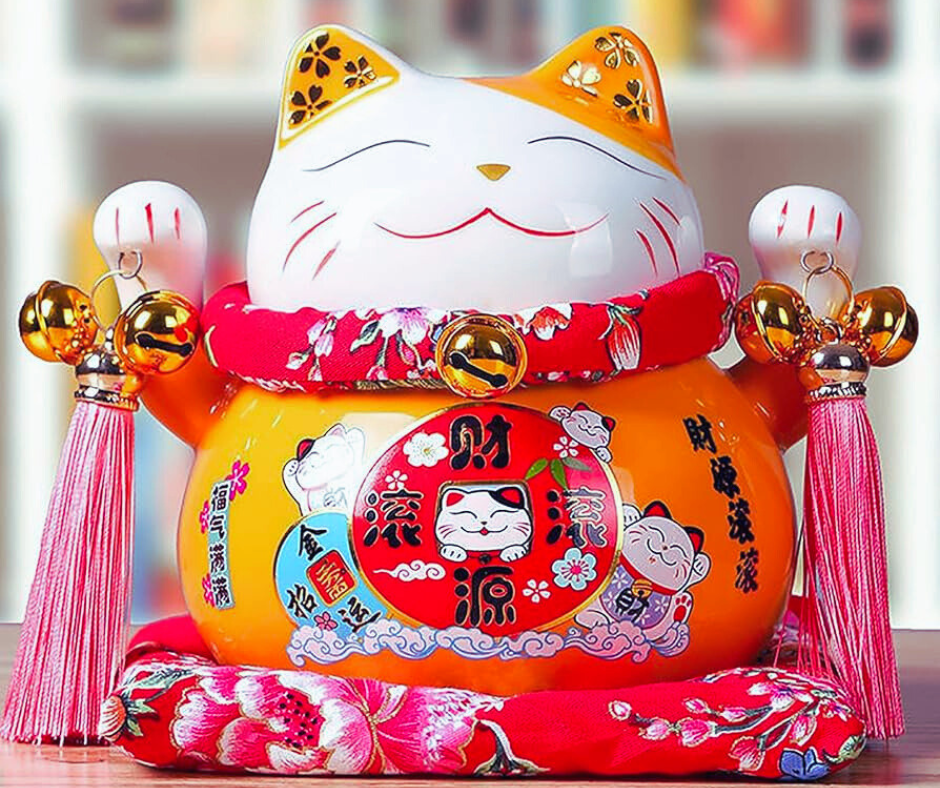 Outra característica interessante do Maneki-neko são os objetos que ele segura. A maioria das figuras traz uma moeda oval, conhecida como koban, que era usada no período Edo e simboliza riqueza. Em muitas versões, a moeda tem gravado o valor de 10 milhões de ryo, que representaria uma imensa fortuna.