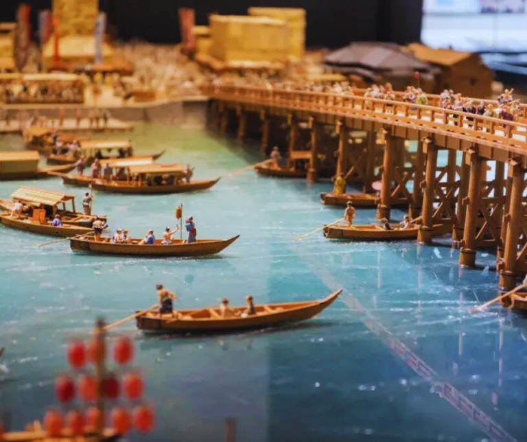 A história de Tóquio começa no século 12, quando ainda era uma pequena vila de pescadores chamada Edo. Foi somente em 1603, quando Tokugawa Ieyasu estabeleceu o governo shogunato na cidade, que ela começou a ganhar importância nacional. Em 1868, após a Restauração Meiji, a capital do país foi transferida oficialmente de Kyoto para Edo, que passou a se chamar Tóquio — “capital oriental”. Desde então, Tóquio se transformou drasticamente. Foi devastada pelo Grande Terremoto de Kanto em 1923 e novamente por bombardeios durante a Segunda Guerra Mundial. No entanto, como uma Fênix, a cidade renasceu das cinzas e se reinventou com impressionante rapidez, tornando-se um símbolo de resistência e progresso.